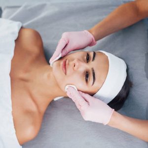 Close up view of woman that lying down in spa salon and have face cleaning procedure.